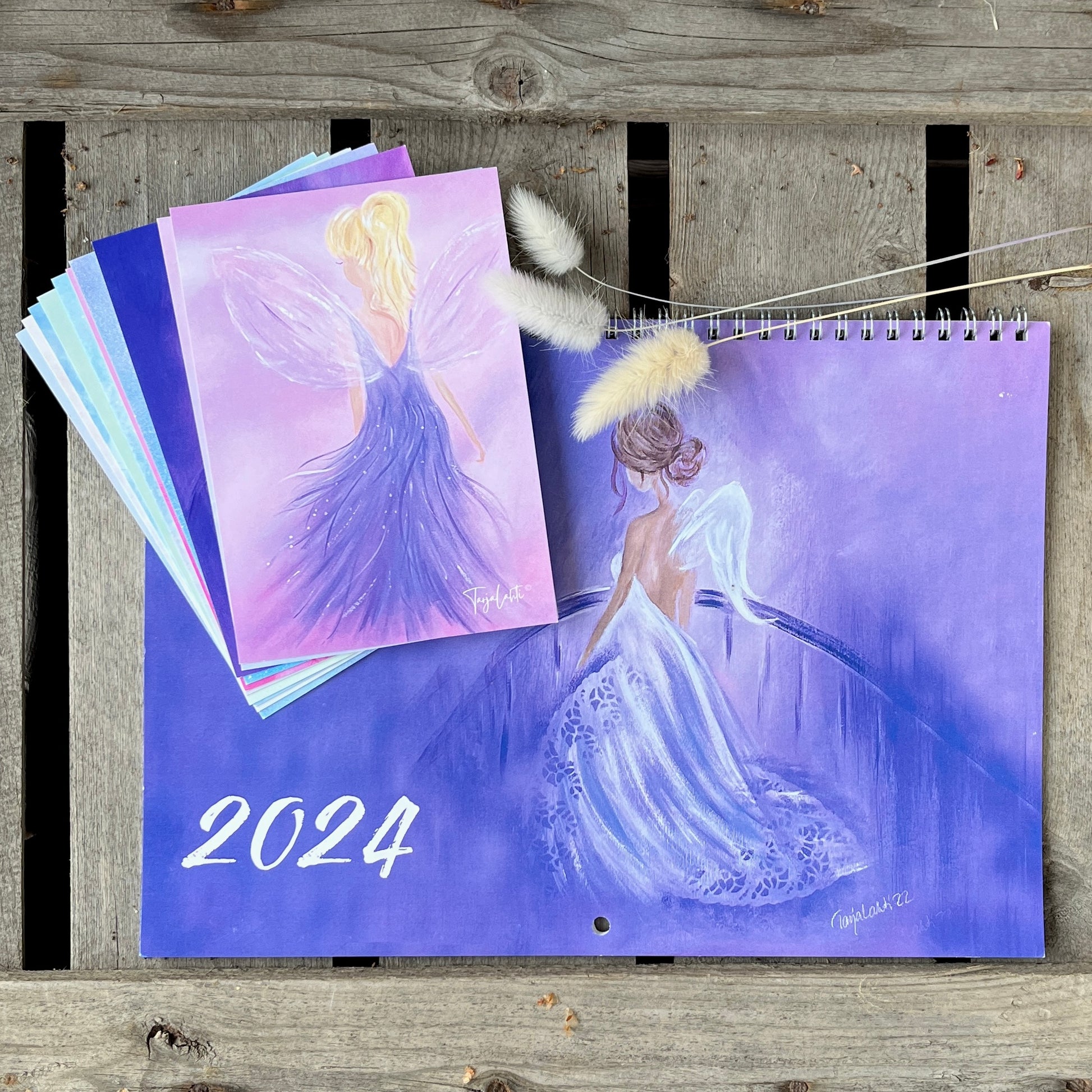 Seinäkalenteri ja 10 postikorttia laatikon päällä